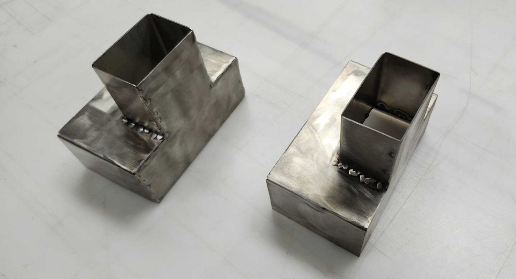 Close-up of tack welded seams on a laser-cut stainless steel distribution funnel.